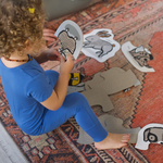 Kisgyermek kezében tartott kisállatos kirakódarab vidám játék közben